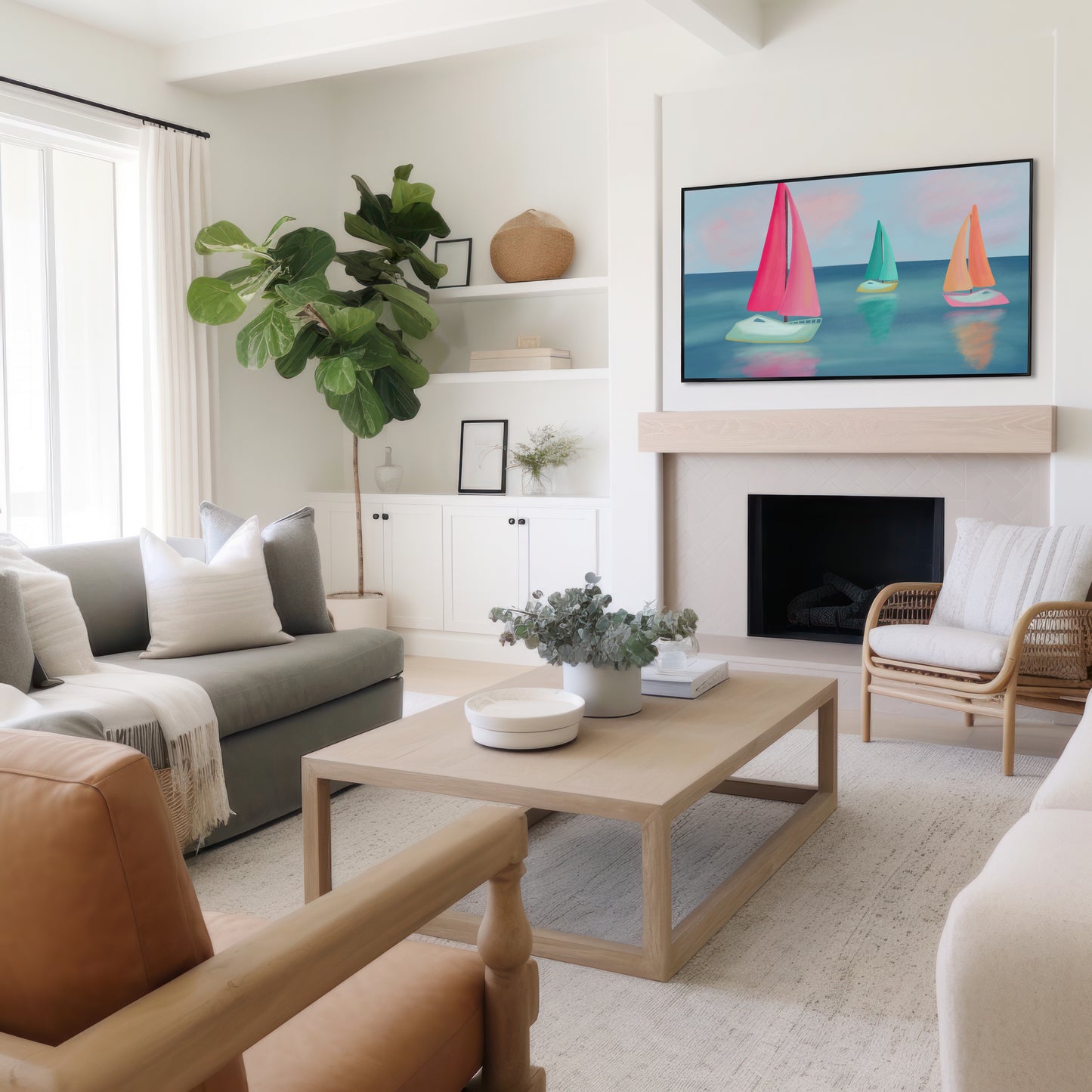 A bright, modern living room with a light wood coffee table, a gray sofa, a brown leather armchair, and a framed sailboat painting above a fireplace.